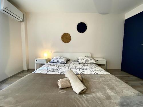 een slaapkamer met een bed met twee handdoeken erop bij Spacieux, Climatisé, Quartier Calme, Proche Château, Le Cocon De Joy in Carcassonne