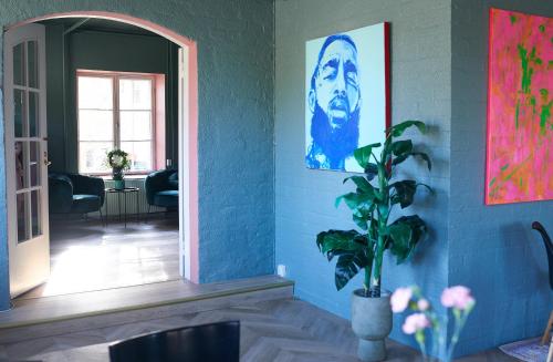 una habitación con una pintura en la pared y una planta en B&B Korsman Hanko, en Hanko