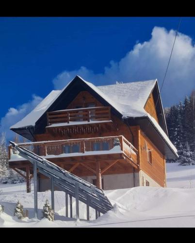 a log cabin in the snow with snow at Gorczańska Chata z tarasem widokowym in Poręba Wielka