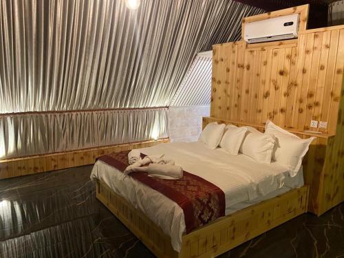 1 dormitorio con 1 cama con toallas en Rum Stars Camp, en Wadi Rum