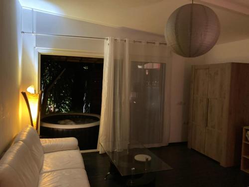 a living room with a white couch and a glass table at Un jour ailleurs in Saint-Pierre