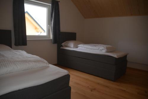 2 Einzelbetten in einem Schlafzimmer mit Fenster in der Unterkunft Dijkstra`s Cottage 679 in Kötschach