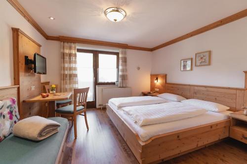 a bedroom with a large bed and a desk and a chair at Feldinggut in Bad Hofgastein