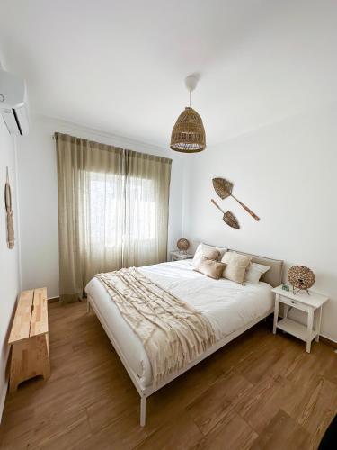 Un dormitorio con una gran cama blanca y una mesa en Sanzi Country House en Tavira