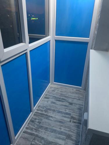a room with four windows and a tiled floor at Апартаменты Экибастуз in Ekibastuz