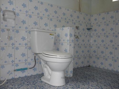 a white toilet in a bathroom with blue tiles at Pasai Beach Lodge in Ko Yao Noi