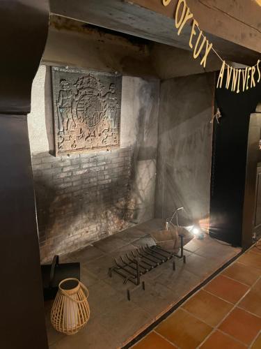 a room with a stone fireplace with a sign on the wall at Le Mas des Perrines Maison d’Hôtes in Pernes-les-Fontaines