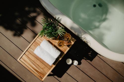 a wooden table with a towel and a bath tub at Atokampis Boutique SPA & Resort 