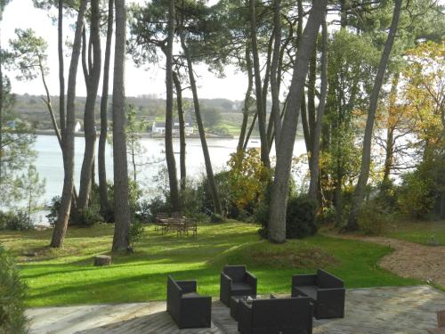 a picnic area with a view of the water and trees at La Villa Bel Ange Hotel in Saint-Philibert