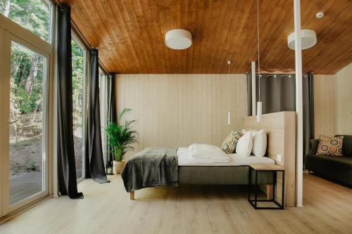 una camera da letto con un letto e una grande finestra di Atokampis Boutique SPA & Resort a Anglininkai