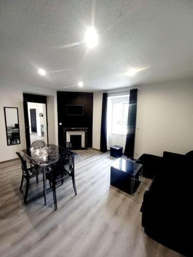 a living room with a table and a couch at Suite du jardin 4 in Chaumont