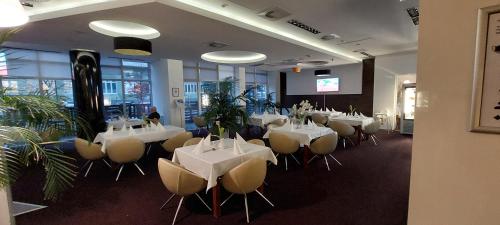 a room with white tables and chairs in a restaurant at Apartament prywatny 242 z aneksem kuchennym w Hotelu Diva in Kołobrzeg