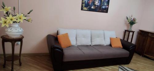 a black couch with orange pillows in a living room at Apartment.md in Chişinău