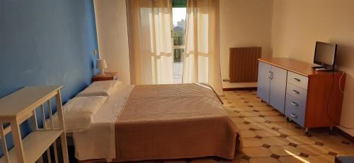 a bedroom with a bed and a dresser and a television at Riviera Apartments in Pietra Ligure