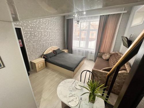 a small living room with a bed and a table at Sport Hotel Terra in Ustʼ-Kamenogorsk