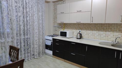 a kitchen with a sink and a microwave at Apartment.md in Chişinău