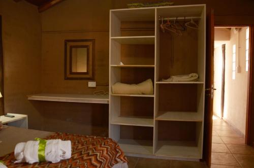 um quarto com um armário com prateleiras e uma cama em Cabañas Bella Alba em São Rafael