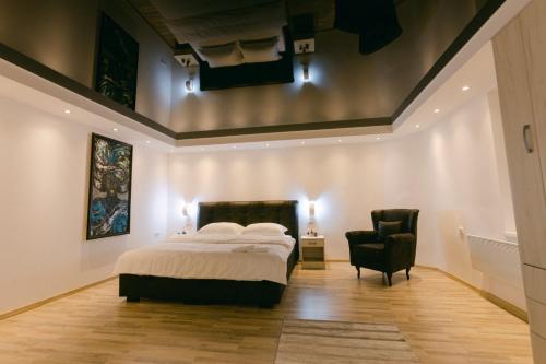 - une chambre avec un lit et une chaise noire dans l'établissement Backa idila, à Bački Gračac