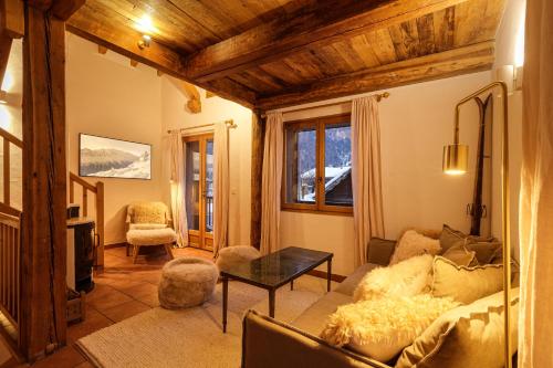 ein Wohnzimmer mit einem Sofa und einem Tisch in der Unterkunft Chalet Ski & in out - Flegere - Free Parking in Chamonix-Mont-Blanc