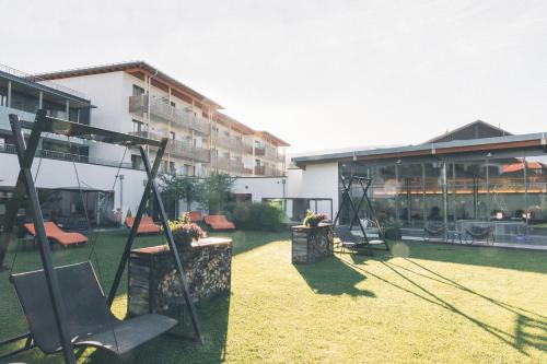 a resort yard with swings and a building at Hotel Eibl-Brunner 4-Sterne-Superior in Frauenau