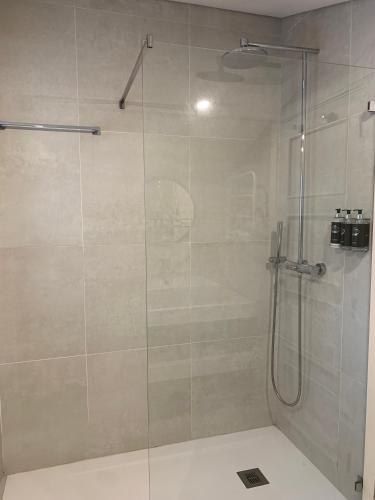 a bathroom with a shower with a glass door at Villa Cerrado das Fontainhas SPA in Sintra
