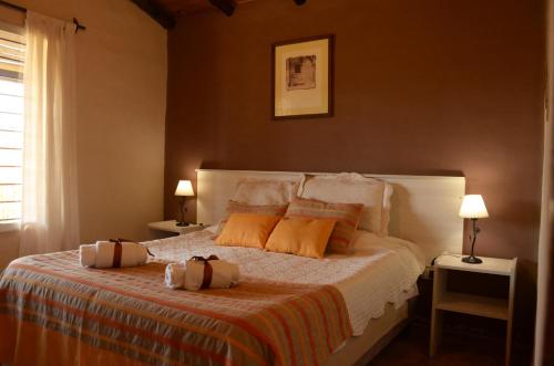 ein Schlafzimmer mit einem Bett mit orangefarbenen Kissen darauf in der Unterkunft Cabañas Bella Alba in San Rafael