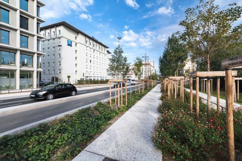 a car driving down a city street with a sidewalk at ibis budget Lyon Villeurbanne in Villeurbanne