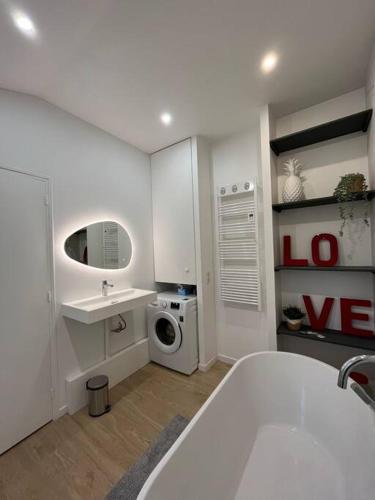 een badkamer met een bad, een wastafel en een wasmachine bij Brand new Tiny House w garden in Saint-Cloud