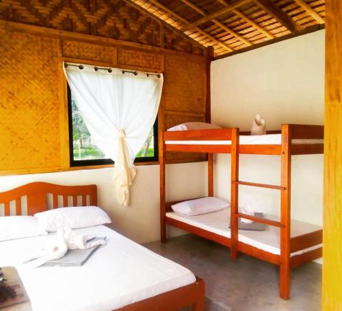 a room with two bunk beds and a window at The Beach House at Dipnay San Fernando, El Nido in El Nido