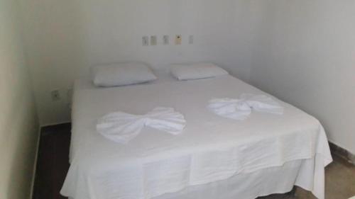 a white bed with two white towels on it at Hotel Aurora in Alagoinhas