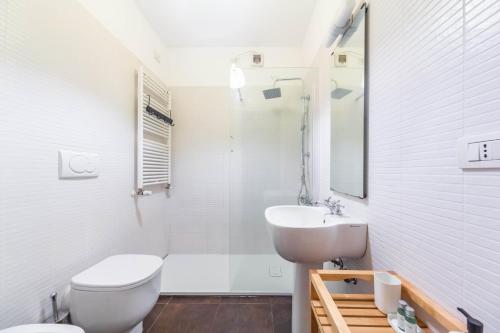 a white bathroom with a toilet and a sink at Cozy Flat 500m from Affori FN! in Milan