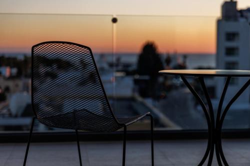 a chair sitting next to a table on a balcony at Regency Boutique Hotel Holiday Suites in Paphos
