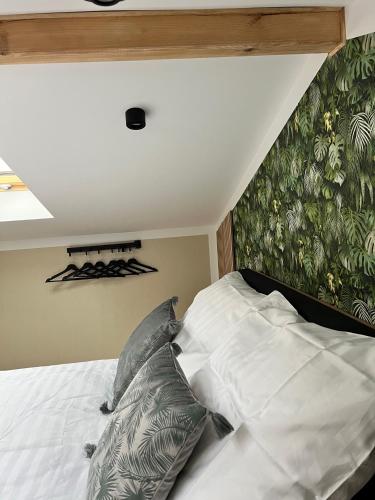 a bedroom with a bed with white sheets and pillows at Casa Kashubia - Nowoczesny dom wakacyjny nad jeziorem - Cisza natura i komfort in Brzeźno Szlacheckie