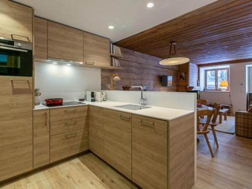 une cuisine avec des armoires en bois et un évier dans l'établissement Élégant appartement rénové avec wifi au cœur du vieux Val-d'Isère, proche des pistes et commodités - FR-1-694-313, à Val dʼIsère