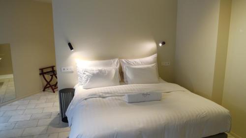 1 dormitorio con 1 cama con sábanas y almohadas blancas en Heirloom Hotels - The Librarian en Ghent