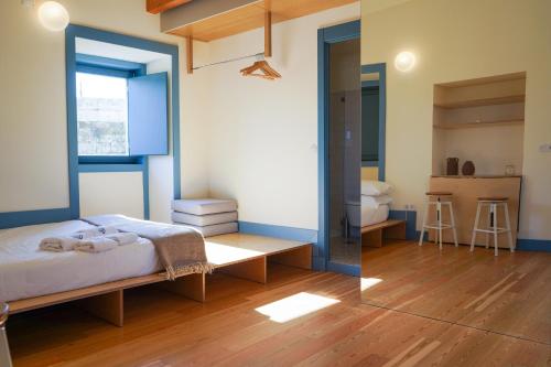 1 dormitorio con cama y espejo en Cellorico de Sabores, en Celorico da Beira