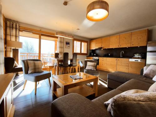 un salon avec un canapé et une table dans l'établissement Appartement lumineux 2 chambres, terrasse sud, parking, WiFi - FR-1-624-128, à Samoëns