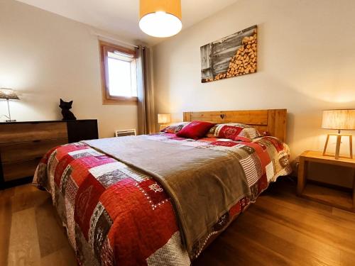 - une chambre avec un lit et un chat assis sur une table dans l'établissement Appartement lumineux 2 chambres, terrasse sud, parking, WiFi - FR-1-624-128, à Samoëns