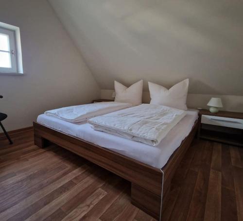 a bedroom with a large bed with white sheets and pillows at Erbgericht Putzkau in Putzkau