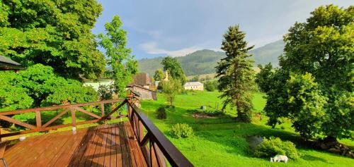 Blick auf ein grünes Feld mit einer Holzbrücke in der Unterkunft Drevenica Borovianka in Veľké Borové