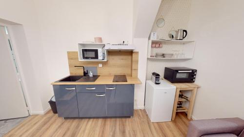 una piccola cucina con lavandino e forno a microonde di Beau T2 2eme étage - hyper centre - proche gare & plage a Le Havre