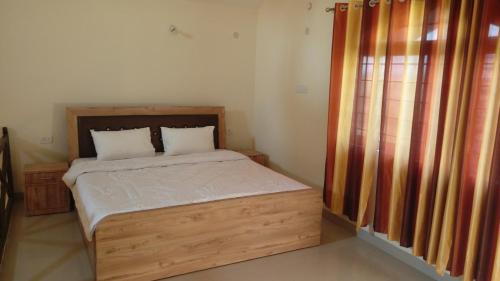 a bedroom with a wooden bed and a window at Aakriti NS71 in Bhopal