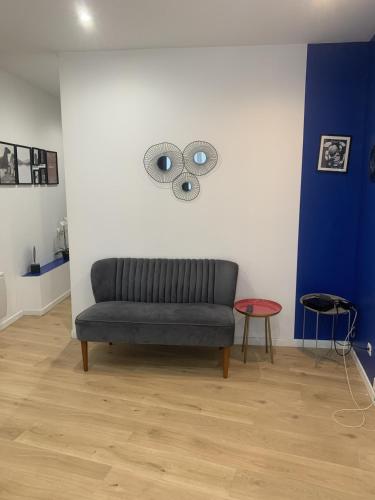 - un canapé dans une chambre dotée d'un mur bleu et blanc dans l'établissement Atelier Tabarly, à Brest