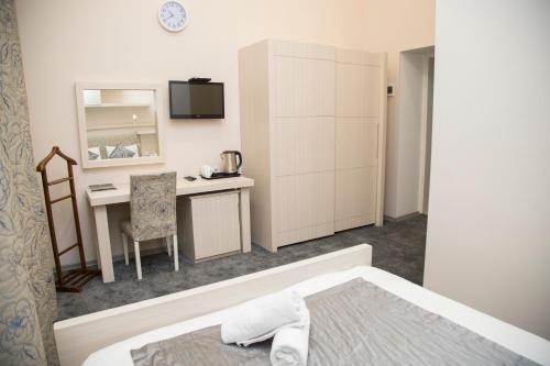 Cette chambre comprend un lit, un bureau et une table. dans l'établissement Bristol Hotel, à Baku