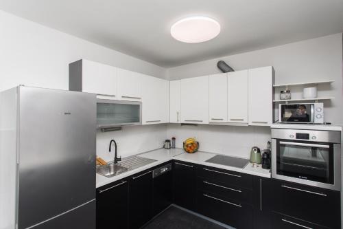 斯普利特的住宿－BEUS DOWNTOWN，厨房配有白色橱柜和不锈钢冰箱