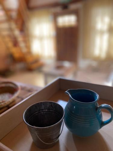 a blue vase sitting next to a cup on a table at del ANDINO.USH in Ushuaia
