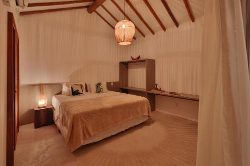 a bedroom with a large bed and a lamp at Pousada Tatuá in Pôrto de Pedras