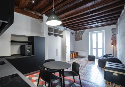 uma cozinha e sala de estar com mesa e cadeiras em Piazza Mascheroni Home em Bérgamo