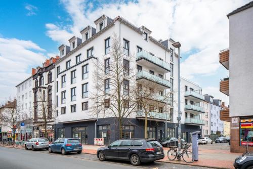 un edificio blanco con coches estacionados frente a él en Liberty Home Platinum - Apartments, en Hannover