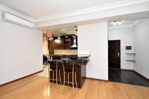 a kitchen with white walls and a bar with stools at Prime Apartment 2 Bedroom In The Center Of Yerevan,Near Republic Square in Yerevan